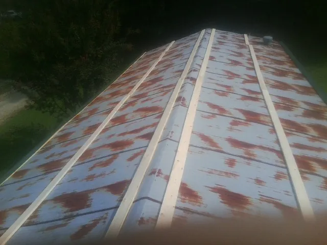 Rusted metal roof panels with new wood purlins before replacement — Storm Damage Roof Repair in College Corner by Roofing Brothers