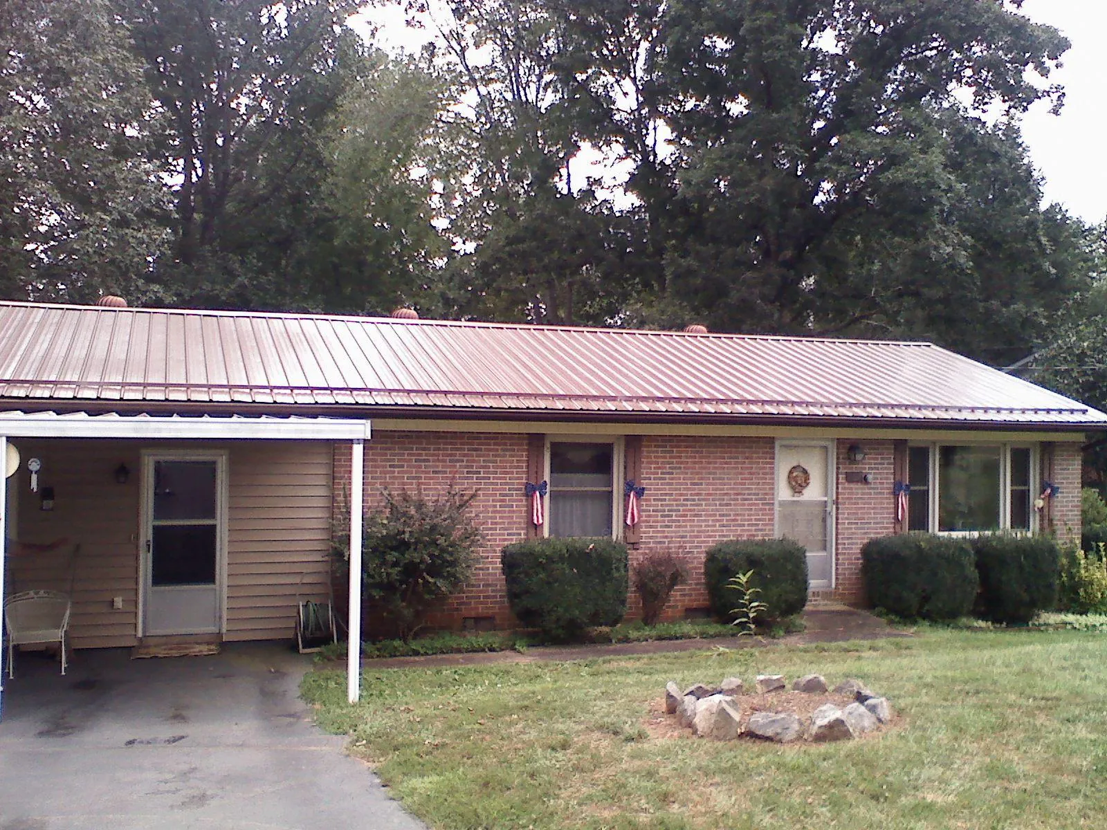 Bronze metal roof and carport on a brick ranch home — Roof Repair work by our crew in College Corner
